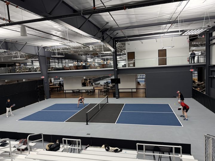 Indoor courts at Greystone seen from above, with players mid-rally