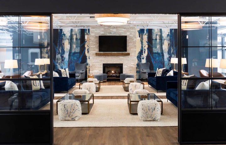 The fireside mezzanine lounge at Greystone, with sofas, a stone fireplace and a court view