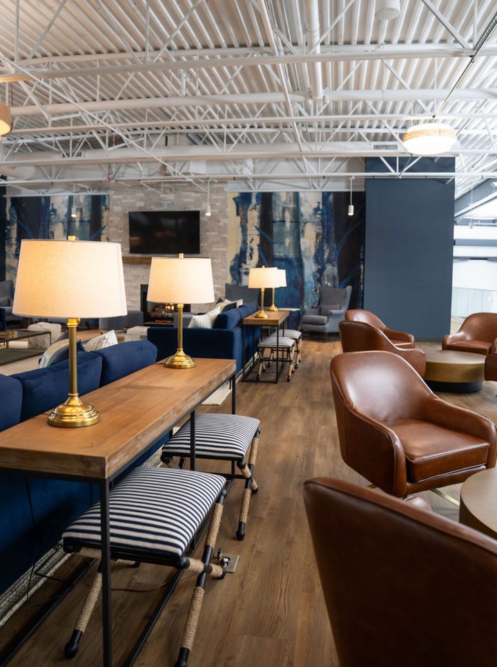 The fireside mezzanine lounge at Greystone, with sofas, a stone fireplace and a court view