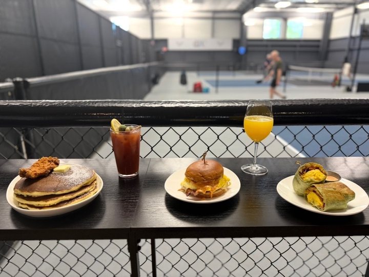 Brunch at the court rail: chicken and pancakes, a breakfast sandwich, a breakfast burrito, a Bloody Mary and a mimosa